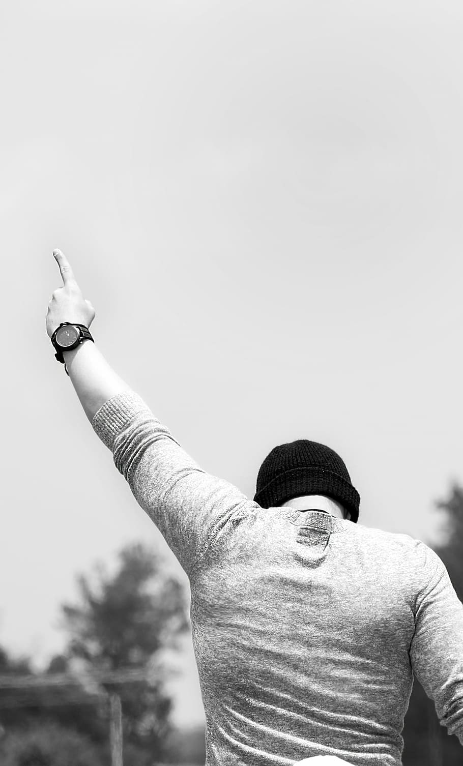 man, wearing, knit, hat, pointing, left, hand, sky, day, urban