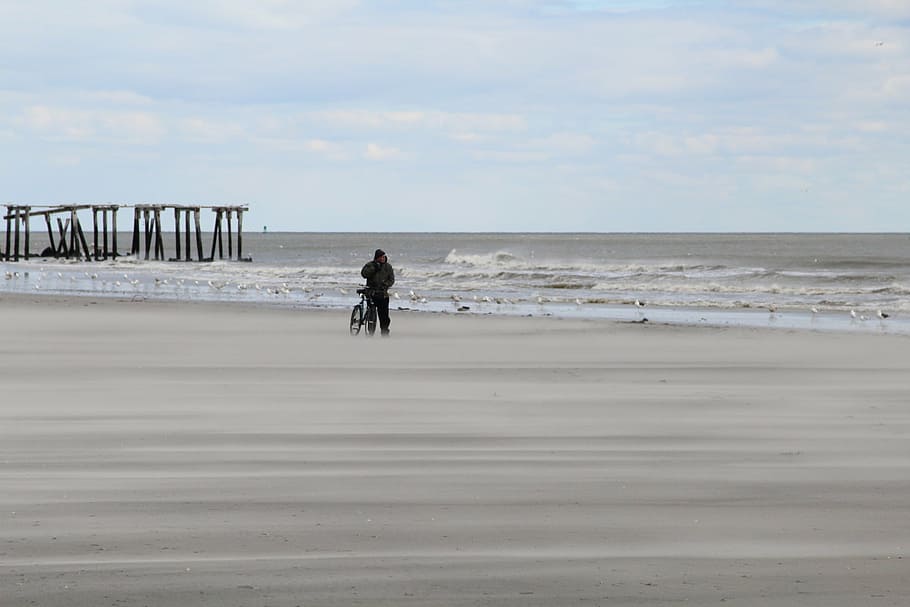 person, standing, seashore, bike, daytime, sea, ocean, water, waves, nature