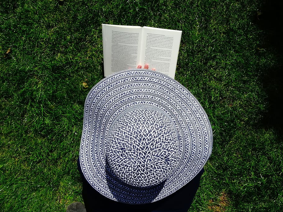 person, holding, gray, sun hat, hat, book, read, relax, grass, books