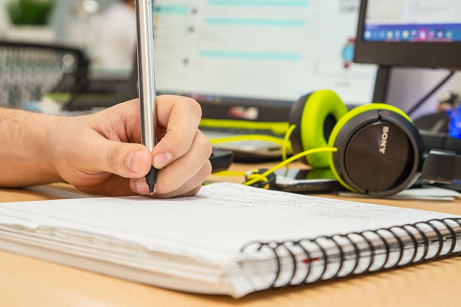 person, holding, black, ball point pen, book, desk, hand, handwritten, headphones, man