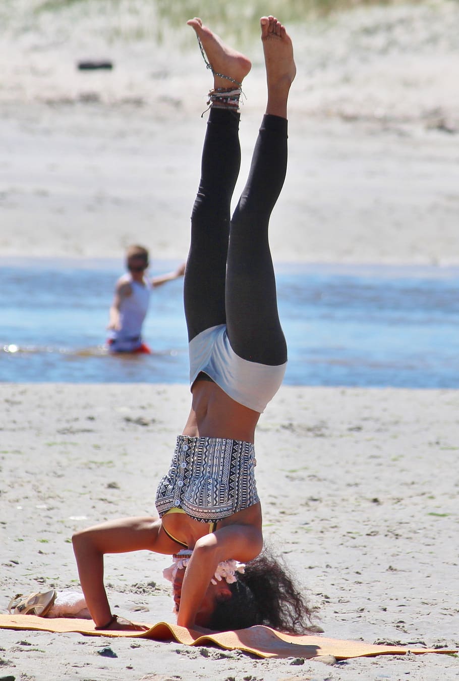 mulher, em pé, de cabeça para baixo, tapete de ioga, ioga, praia, relaxamento, areia, desportivo, bonita