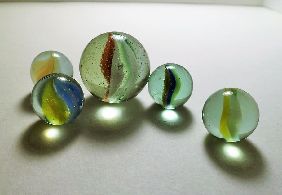 cinco brinquedos de mármore, bolinhas de gude, bolas, transparência, decoração, brilho, vidro, cores, gotas, jóias