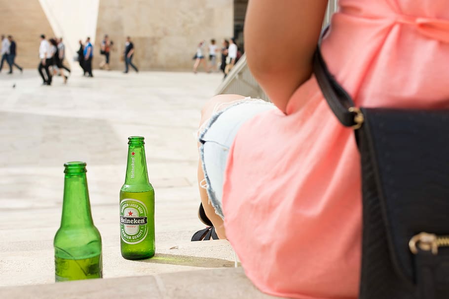 botella de cerveza Heineken, cerveza Heineken, botella de cerveza, cerveza, bebida, manos, Heineken, afuera, personas, al aire libre