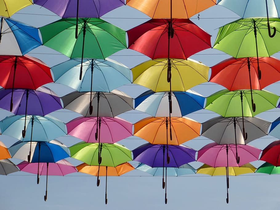 assorted-color handheld umbrella, umbrella, color, red, green, yellow, blue, sky, blue sky, decorative street