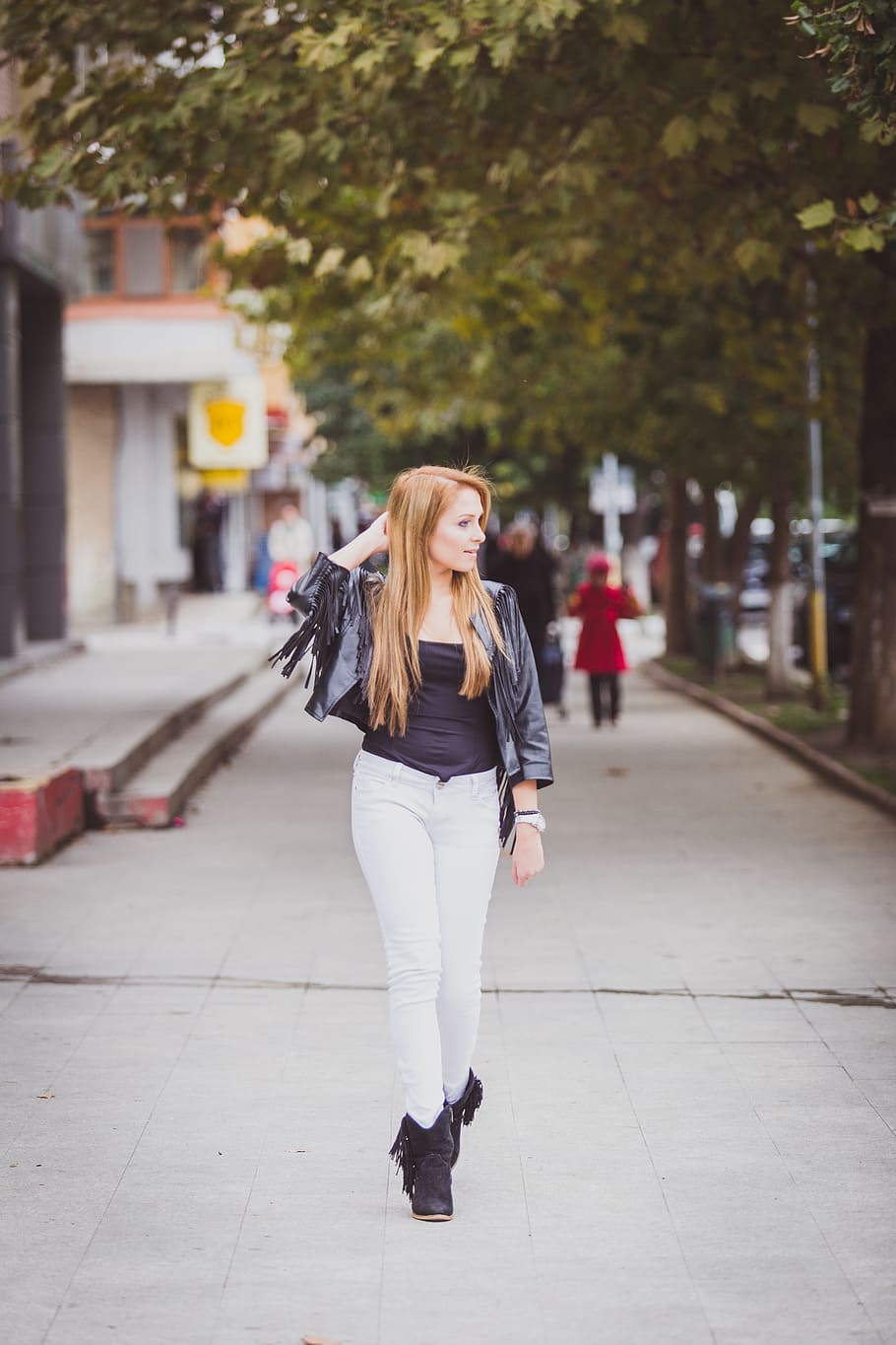 woman, wearing, black, scoop-neck blouse, white, fitted, jeans, boots outfit, standing, trees