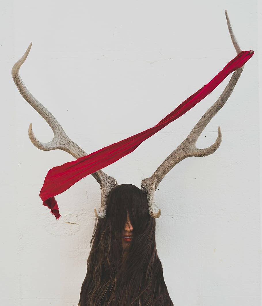 red textile, people, woman, horn, hair, face, wall, white, women, one person