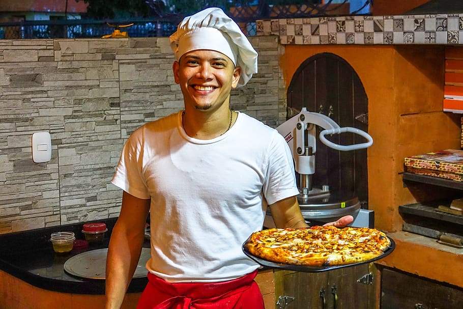 man, holding, baked, standing, black, brown, wooden, cabinet, Pizza, Restaurant