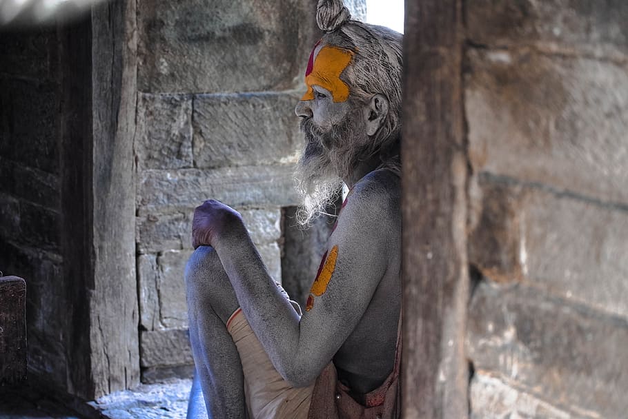 man, sitting, leaning, brown, wooden, wall, holy man, nepal, hindu, religion