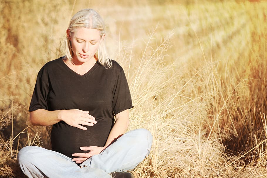 pregnant, woman, wears, black, v-neck t-shirt, gray, pants seats, brown, grass field, daytime