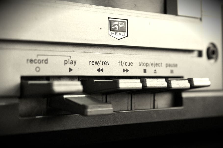 tilt-shift lens photography, cassette tape player, record player, jukebox, tape, black and white, sound, close-up, text, indoors