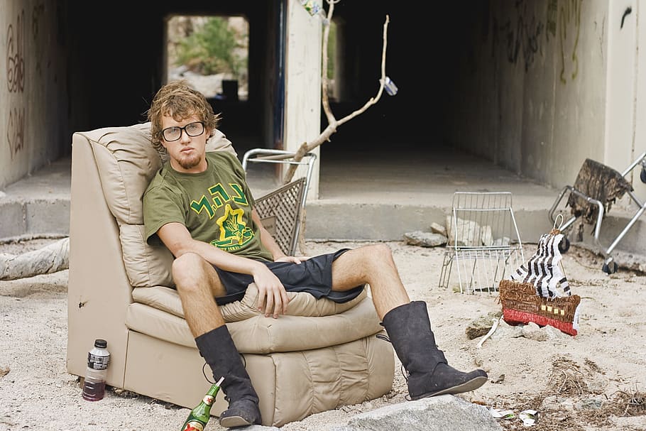 man, green, t-shirt, sitting, leather chair, outdoor, daytime, homeless, homeless man, poverty