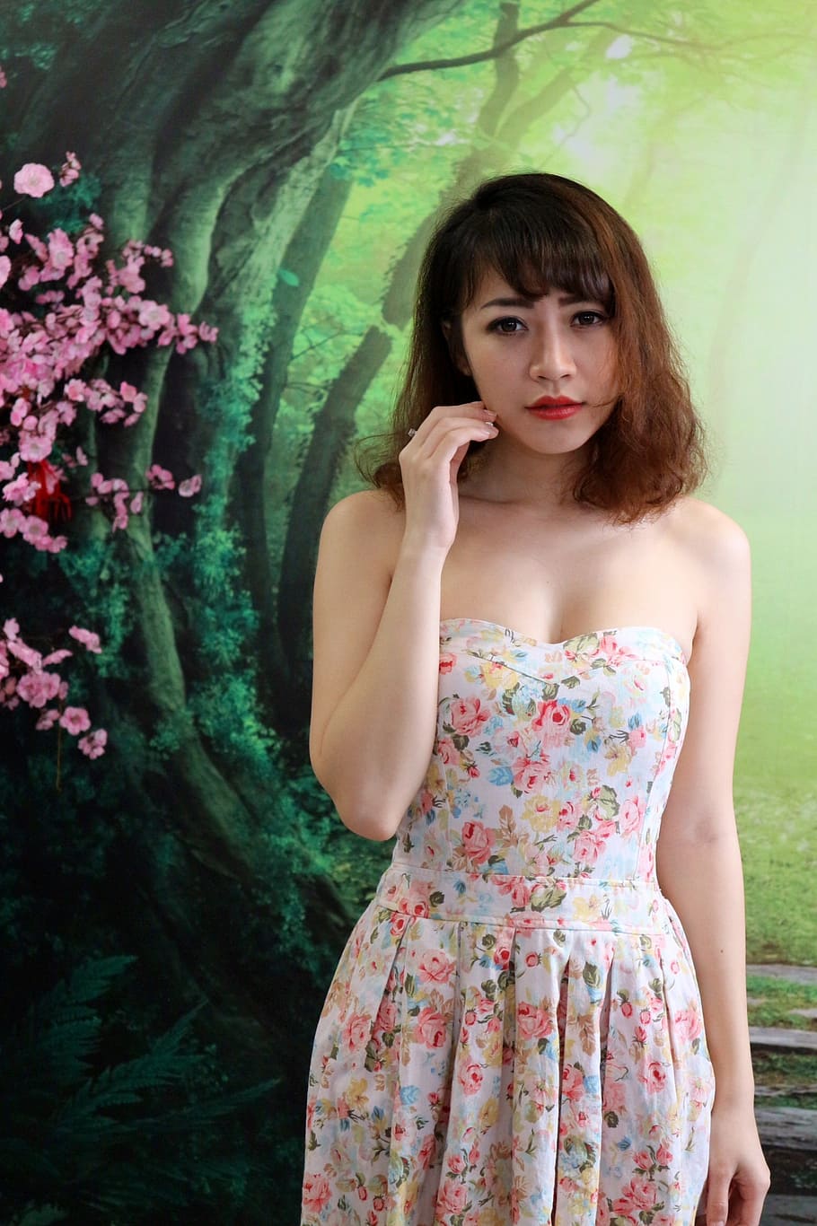 woman, wearing, white, multicolored, floral, strapless dress, standing, green, tree wall painting, beauty