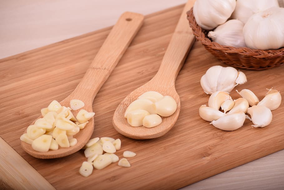 sliced, garlic cloves, placed, two, wooden, ladles, chopping, board, garlic, food
