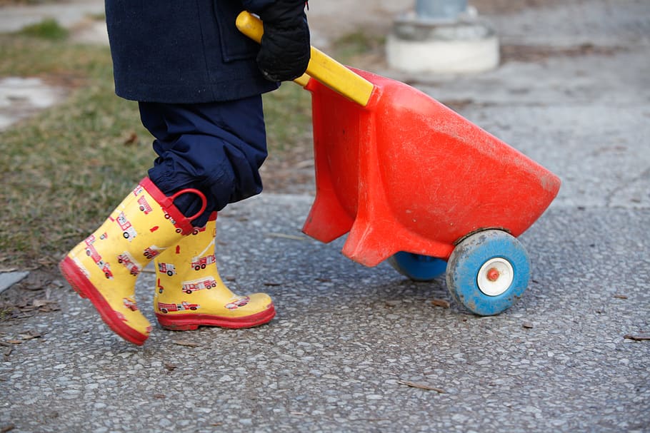 rubber boots, outdoor play, wheelbarrow, autumn, push, work, one person, low section, human body part, city
