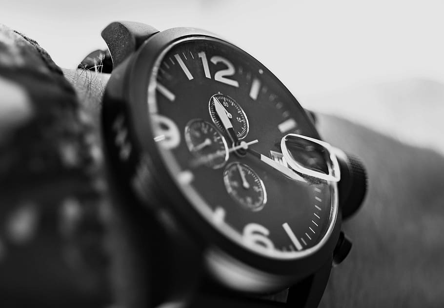 close, photograph, person, wearing, round bezel chronograph, watch, wrist, black and white, minute, time