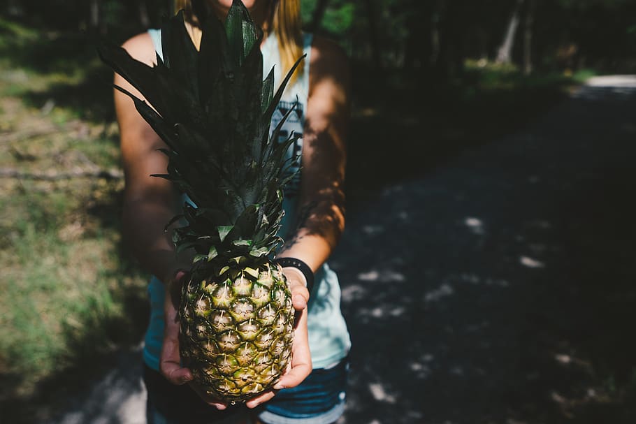 female, female hand, fruit, girl, person, pineapple, tropical fruit, woman, focus on foreground, one person