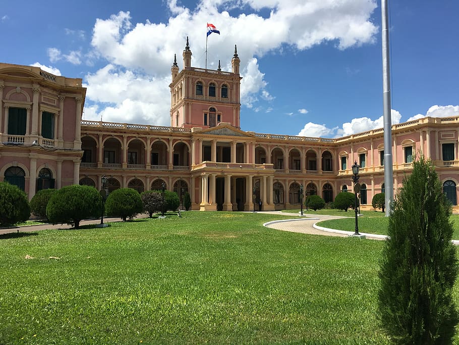brown painted building, paraguay, presidential palace, palace, cloud - sky, flag, sky, architecture, building exterior, grass