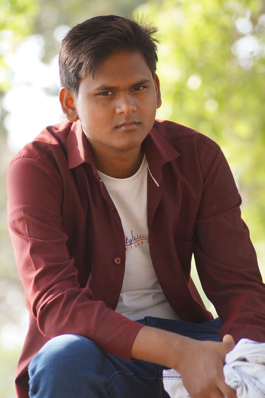 relaxed, indian boy, boy, sitting, three quarter length, front view, casual clothing, real people, one person, leisure activity