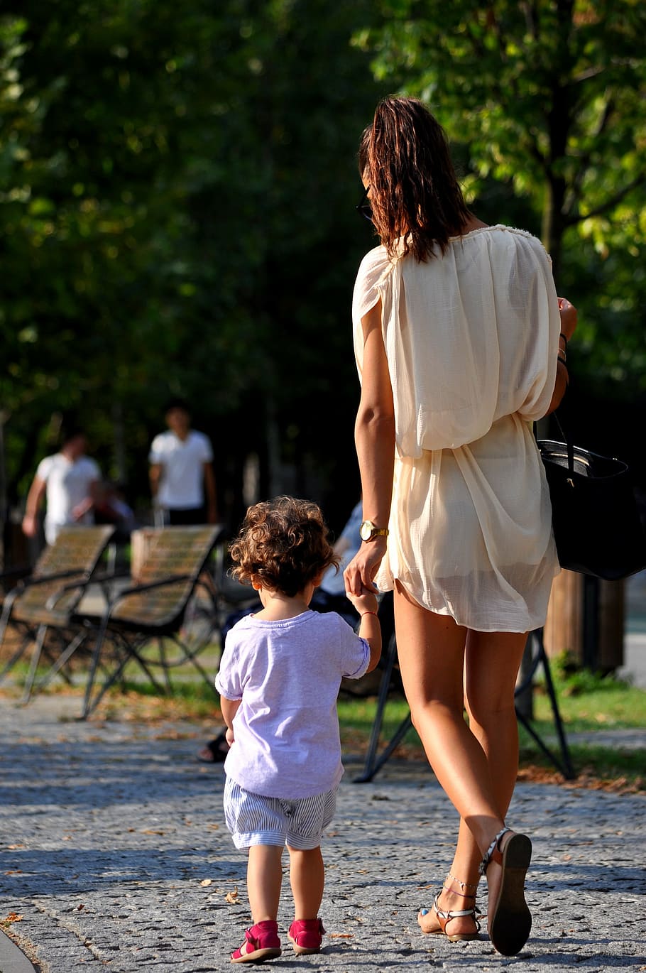woman, wearing, white, dress, holding, hand, toddler, holding hands, mom and daughter, girl