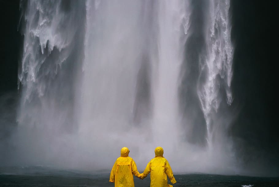 two, person, wearing, yellow, raincoats, front, waterfall, couple, holding hands, people