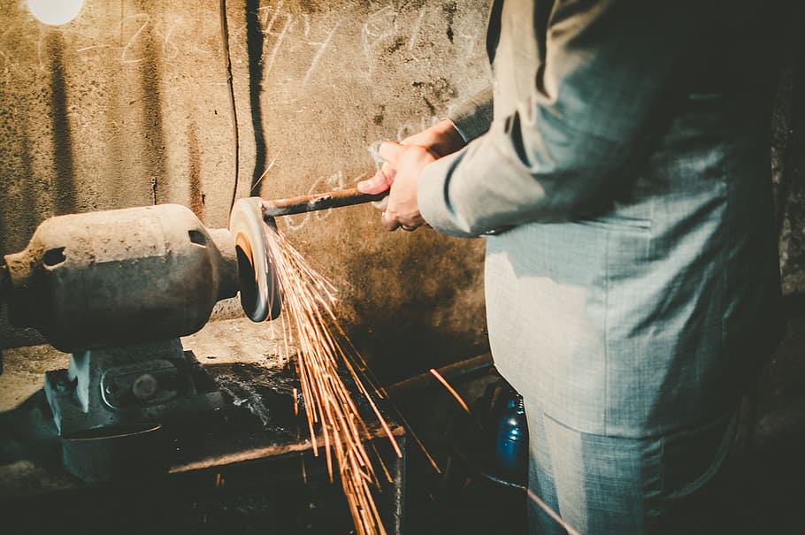 man grinding metal, adult, blur, close-up, designer suit, factory, focus, grinder, industry, light