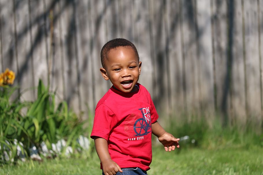 smiling, boy, wearing, red, crew-neck shirt, grass, daytime, toddler, black boy, playful