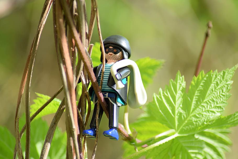 male, toy character, hanging, green, leafed, vine plant, burglary, theft, criminal, figure