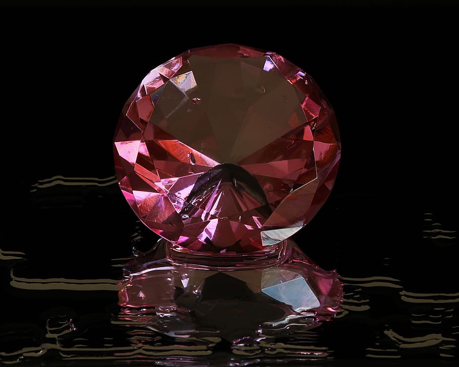 red gemstone, pink diamond, round cut, gem stone, cut glass, facets, reflection, studio shot, indoors, black background
