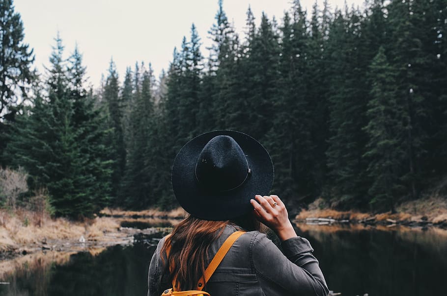 woman, holding, hat, facing, trees, women, s, standing, front, river