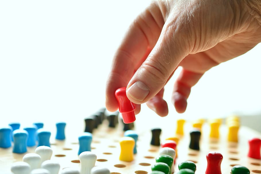 person, holding, multicolored, plastic components, plastic, components, hand, game characters, halma, play stone