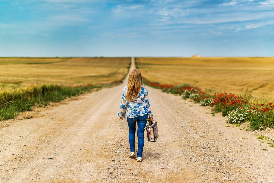 woman, wearing, blue, jeans, floral, long-sleeve shirt, walking, middle, road, daytime