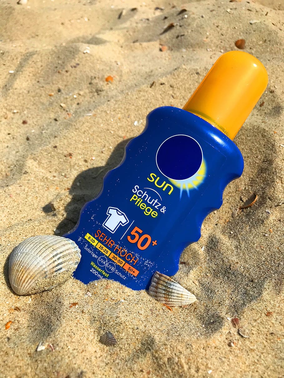 blue-yellow-plastic-bottle-sand-sunscreen-sun-milk-lotion-beach