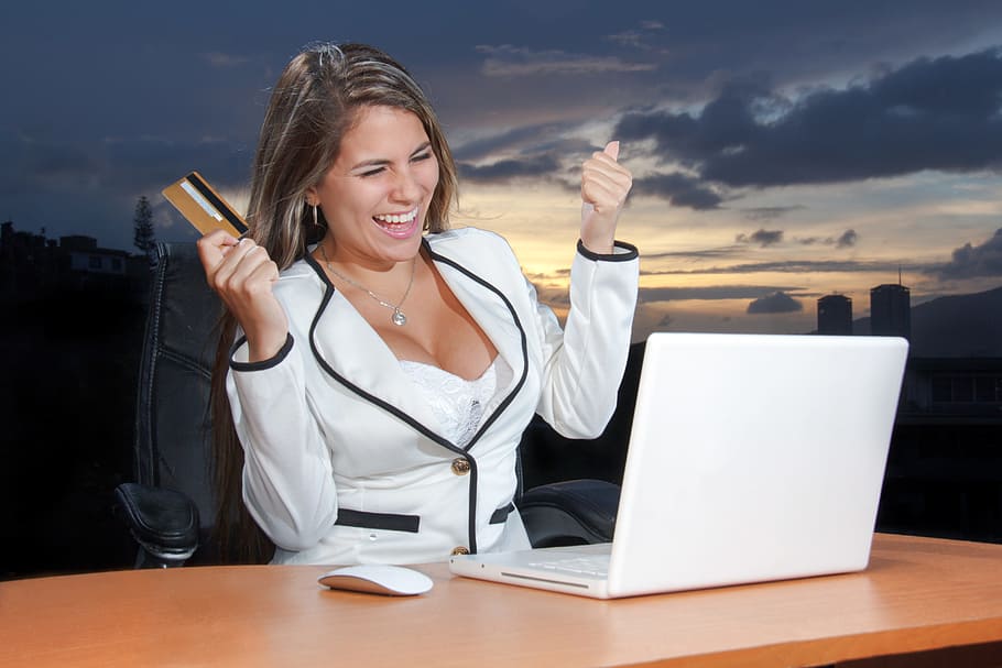woman, white, blazer, holding, card, looking, macbook, marketing online, social media, online