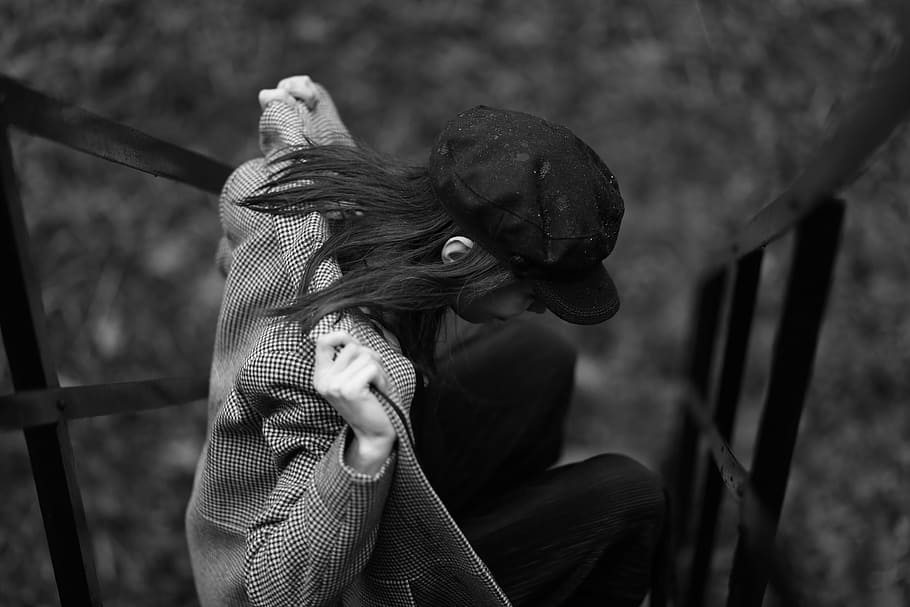 grayscale photography, woman, wearing, jacket, people, cap, coat, sitting, outside, black And White