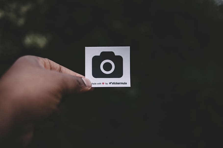 person, holding, white, black, camera print paper, dark, outside, hand, logo, graphics