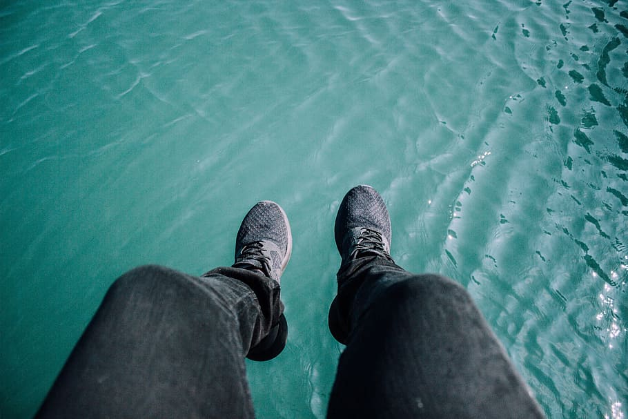 pessoa, vestindo, preto, jeans, par, sapatos de cadarço cinza e preto, corrida, sapatos, azul, água