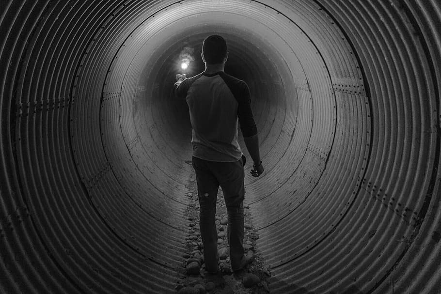 person, standing, inside, tunnel, grayscale, man, guy, flare, light, people