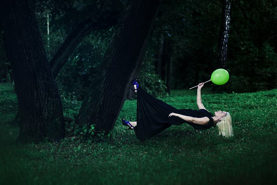 female, wearing, black, sleeveless dress, surrounded, grasses, trunk tree, levitation, weightlessness, girl