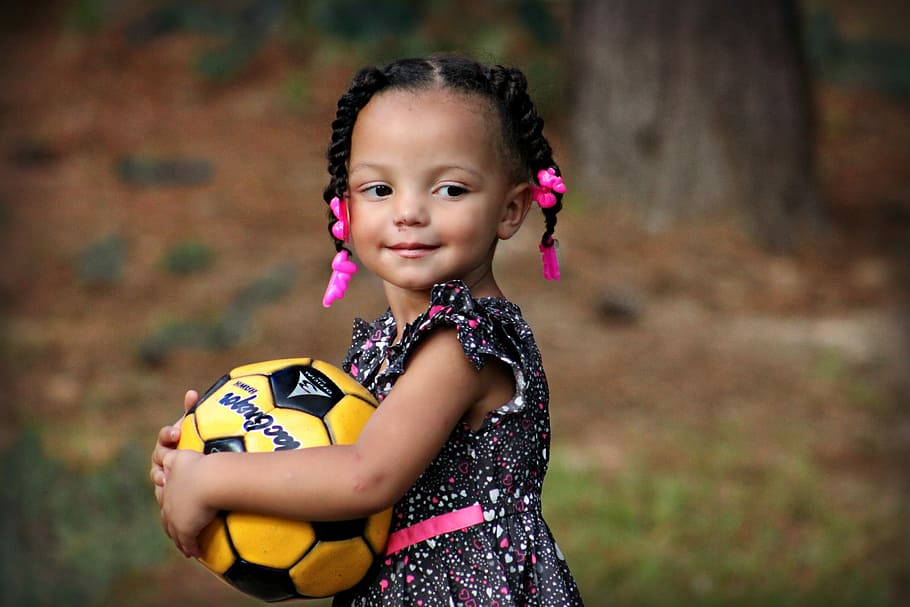 girl, white, pink, black, floral, sleeveless dress, holding, yellow, soccer ball, daytime