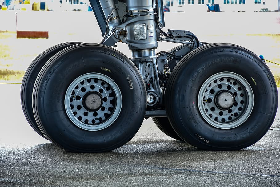 plane tire, maintenance, airliner, tires, terminal, travel, airport, worker, commercial, undercarriage