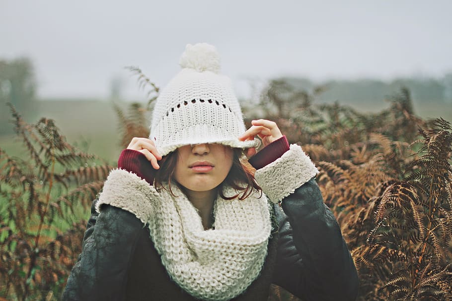 woman, covering, eyes, knitted, cap, brown, leaf bush, selective, focal, daytime