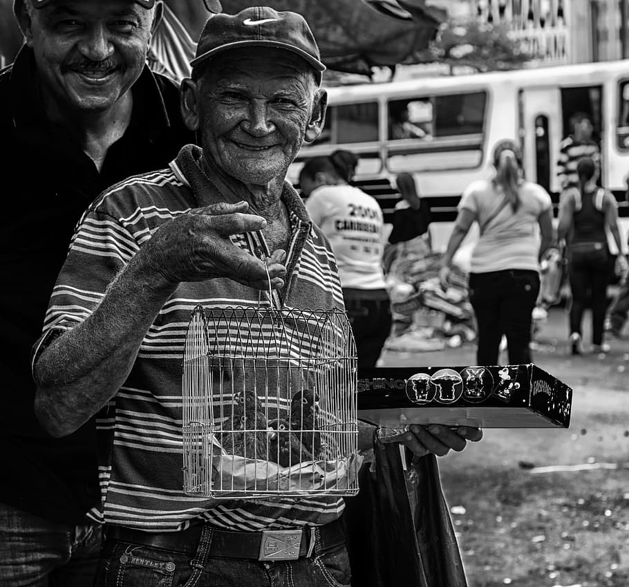 man holding birdcage, man, men, selling parrots, birds, cage, old, senior, maracaibo, venezuela