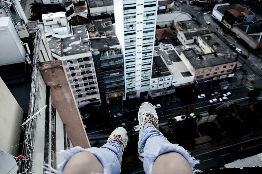 person, sitting, ledge, buildings, feet, shoes, knees, view, vehicle, hotel