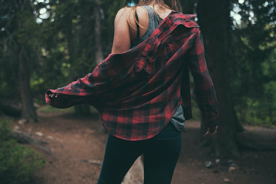 woman, removing, black, red, sport shirt, walking, trees, plaid, long, sleeved