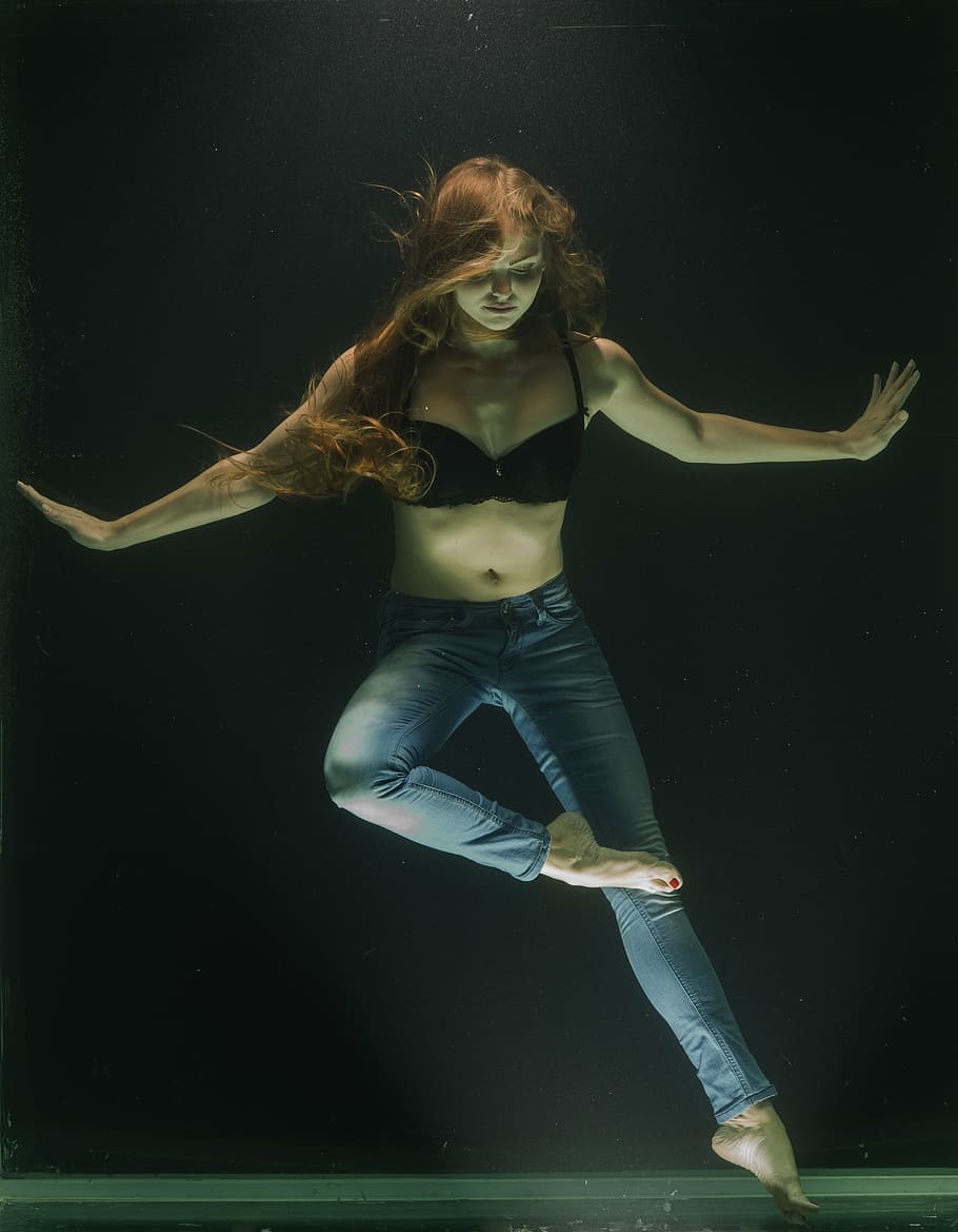 woman, standing, arms, sideways, right foot, reaching, left, knee, underwater, fashion