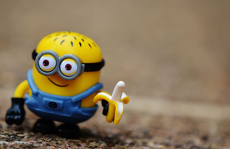 close-up photography, minion, holding, banana plastic toy, funny, toys, children, figure, yellow, cute