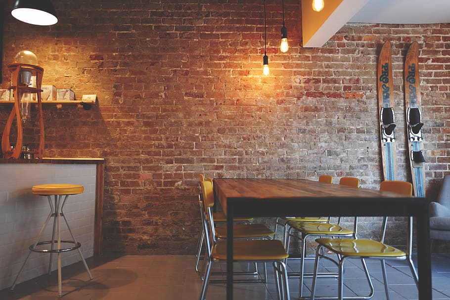 brown, wooden, dining table, yellow, padded, chairs, brick wall \, brick wall, furniture, interior design