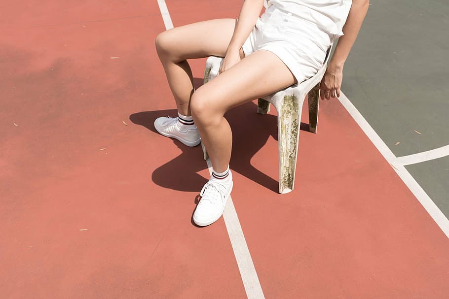 person, wearing, white, shorts, sitting, plastic chair, green, court, people, chair