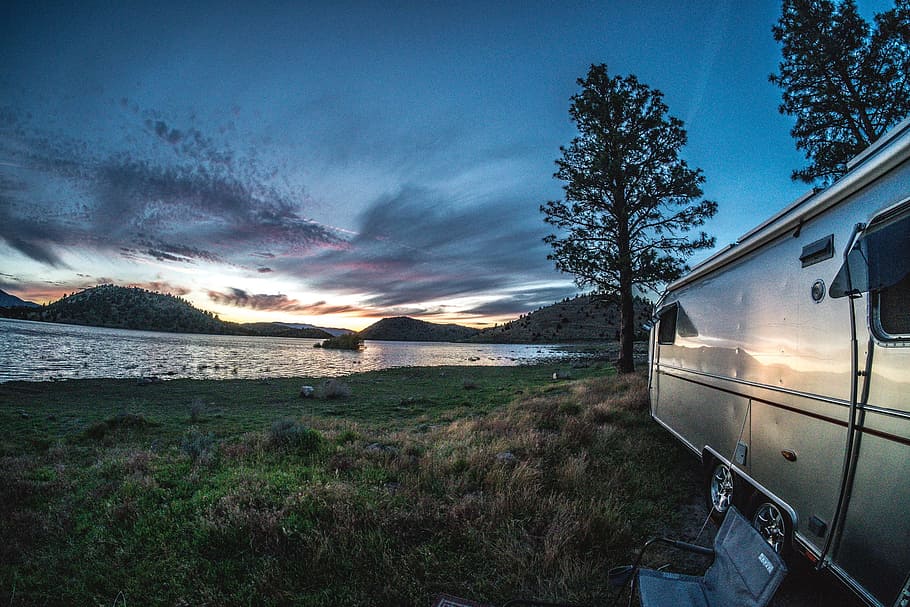 silver travel trailer, body, water, airstream, trailer, rv, camping, sunset, lake, trees