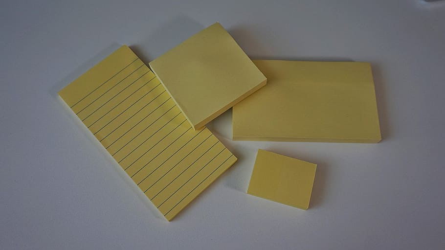 postit, sticky notes, adhesive note, office accessories, memo pad, indoors, studio shot, yellow, gray background, directly above